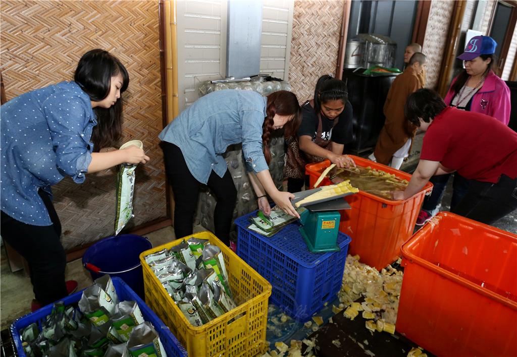 青年們到里佳部落竹筍加工場學習製筍技巧，秤重包裝轎篙筍。