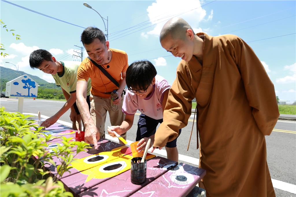 普中美術老師洪明輝指導學生彩繪，慈善院辦公室主任妙仁法師前來關心。