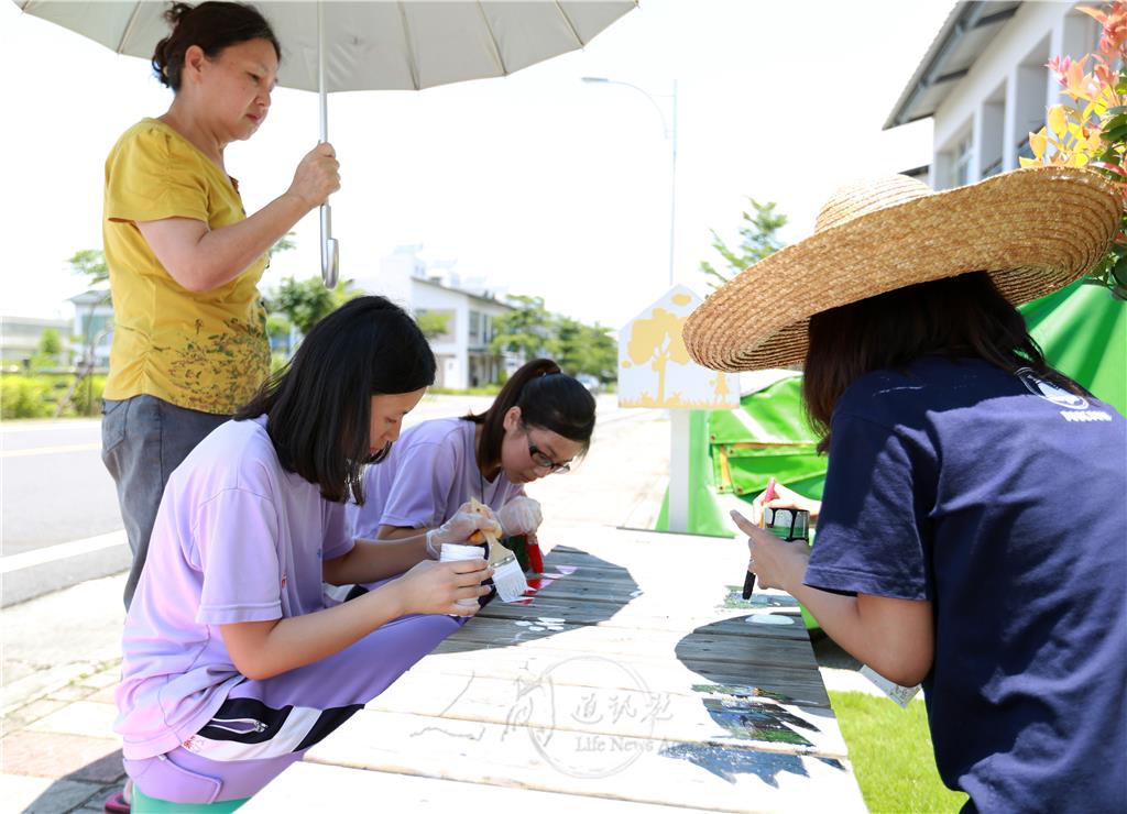 村民不捨學生在大太陽底下彩繪，主動為他們撐傘遮陽。